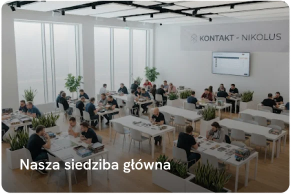 Duża, jasna sala wypełniona ludźmi siedzącymi przy stołach i grającymi w różne gry planszowe podczas spotkania miłośników planszówek.